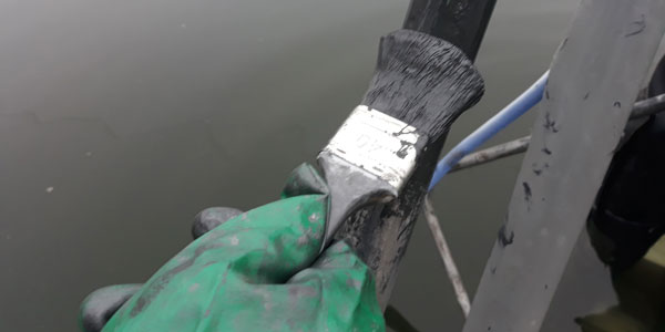 Diver applies Primer Leco S5 corrosion protection to the waterline