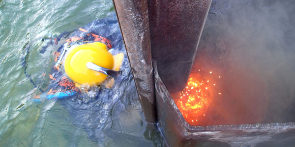Industrijski ronilac reže željezo u vodi Austrija